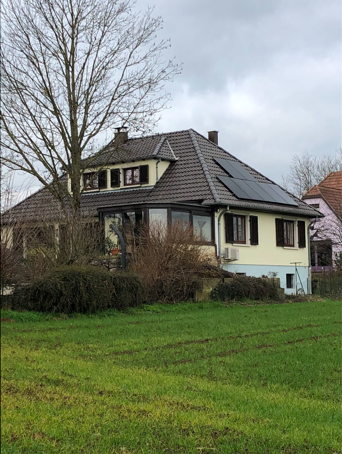 Maison avec panneaux solaires vue depuis le jardin